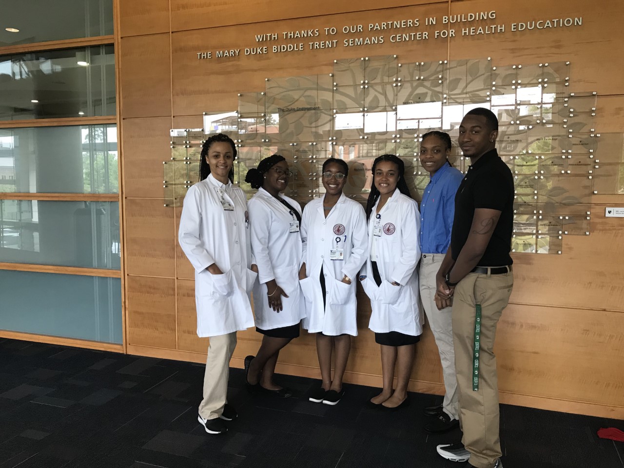Internship group in lab coats posing for a picture together