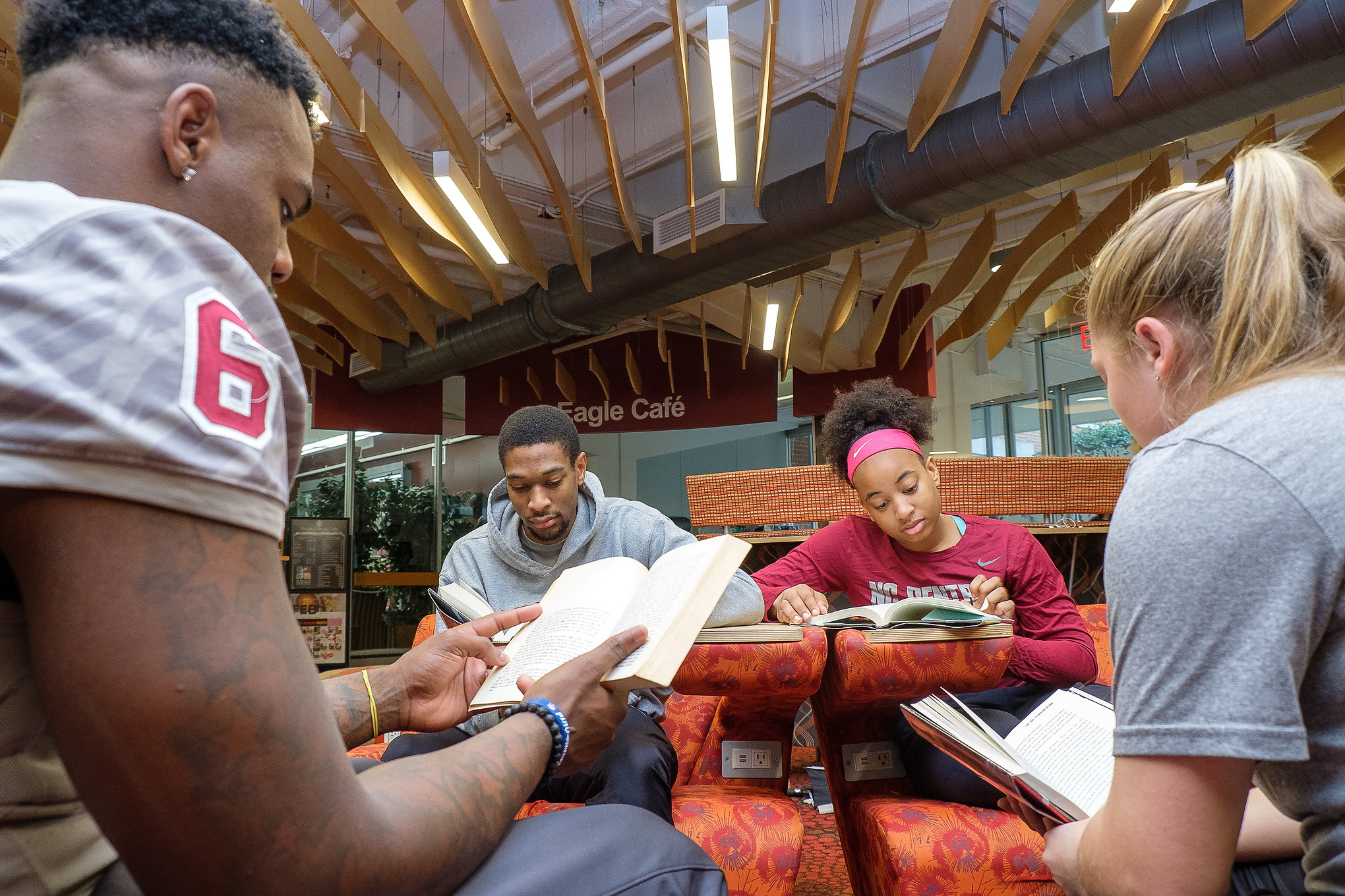 Student athletes studying in library.