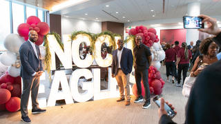 A group of people posing in front of NCCU Eagles sign