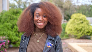 NCCU student with brown shirt, black jacker and 'I voted' sticker