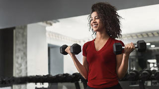 Fitness Woman Doing Biceps Workouts With Dumbbells In Gym