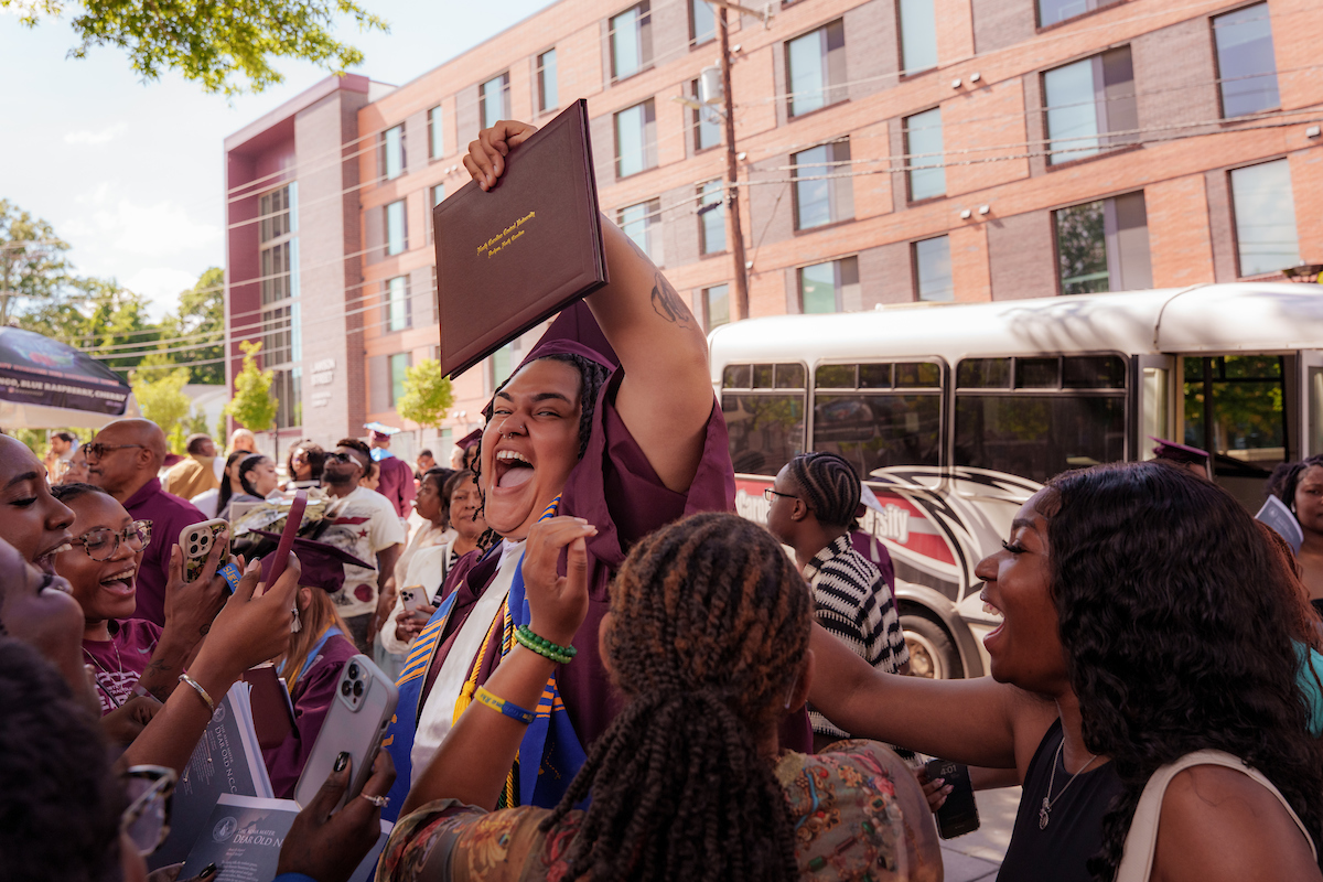 Graduating student celebrating outside of the McClendon-McDougal Arena