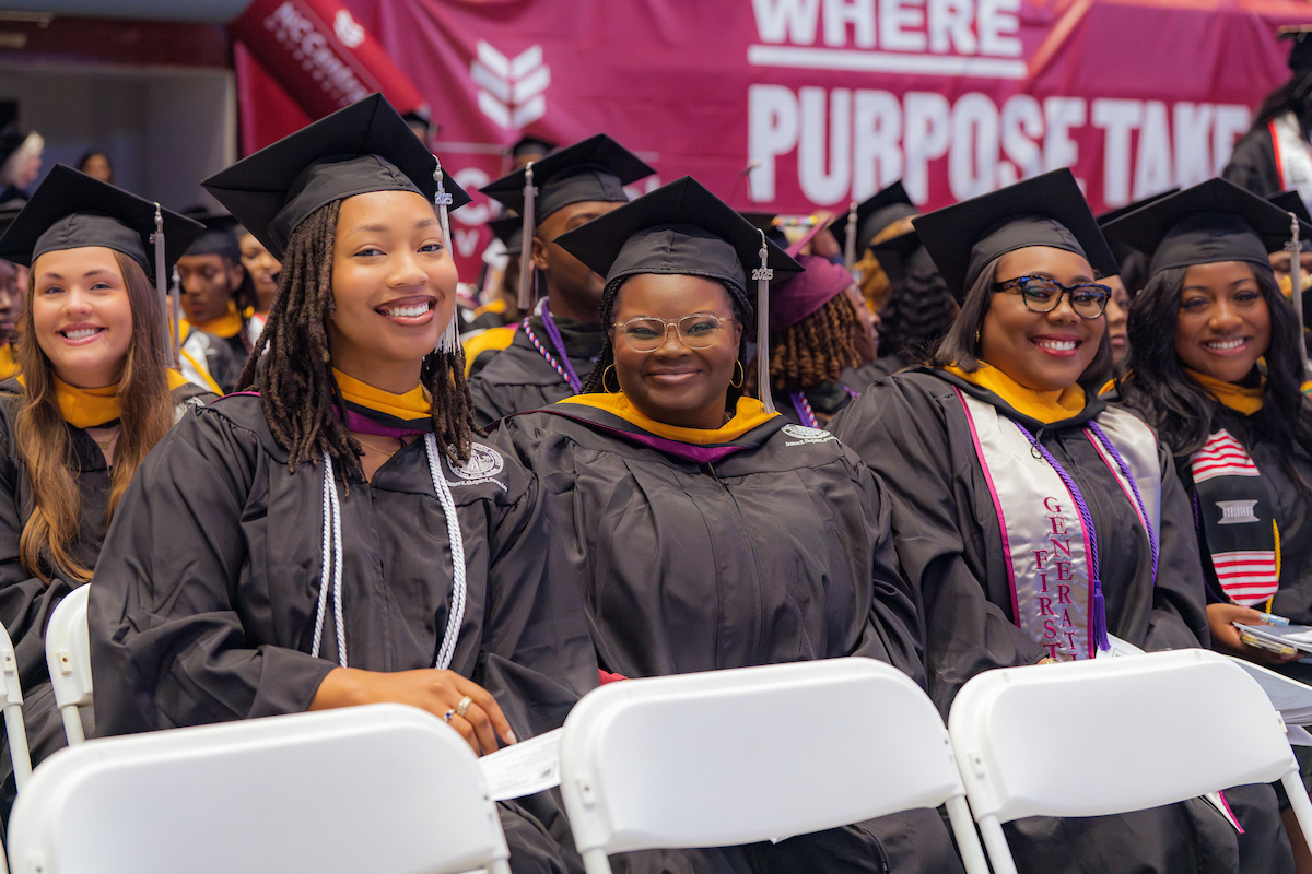 Student posing with their diplomas at commencement