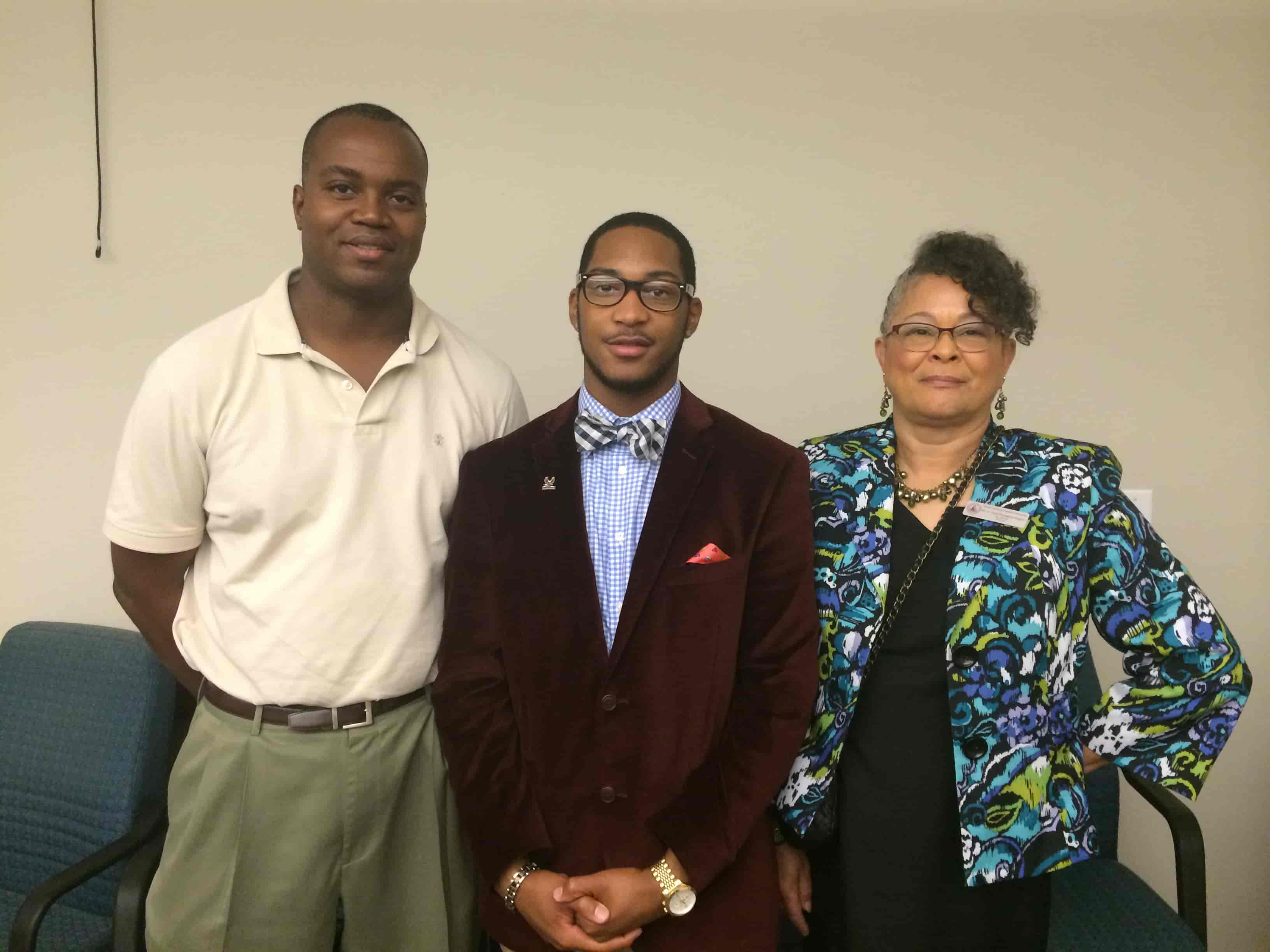 A young intern standing between two mentors