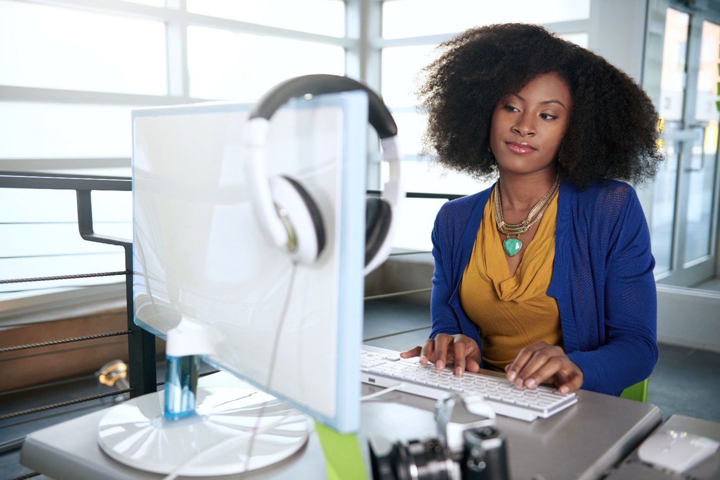 Picture of a woman looking at a computer screen while typing