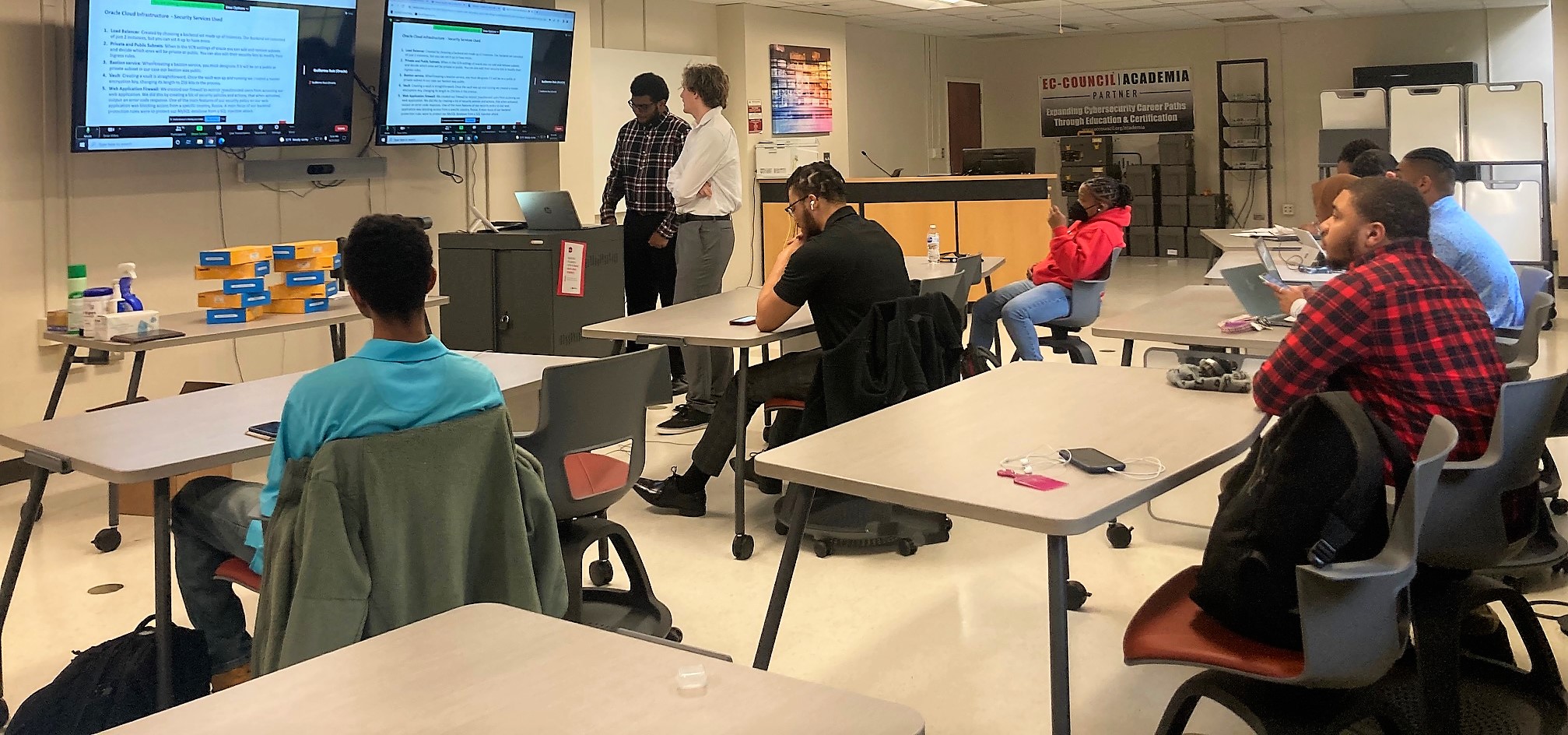 Students in a crowd watch a cybersecurity presentaion