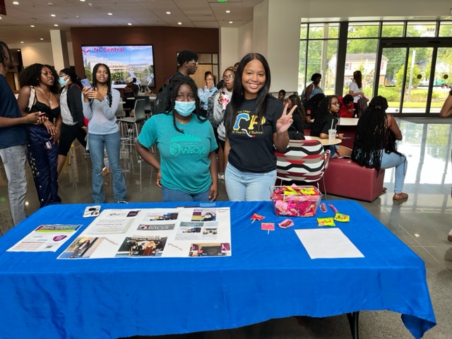 WiCyS Memebers Standing behind their table at an event