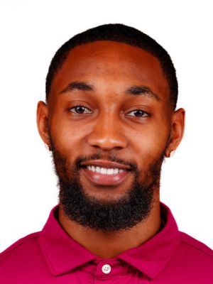 Alanda Williams Jr. headshot portrait, smiling professional wearing a maroon collared shirt against a white background.
