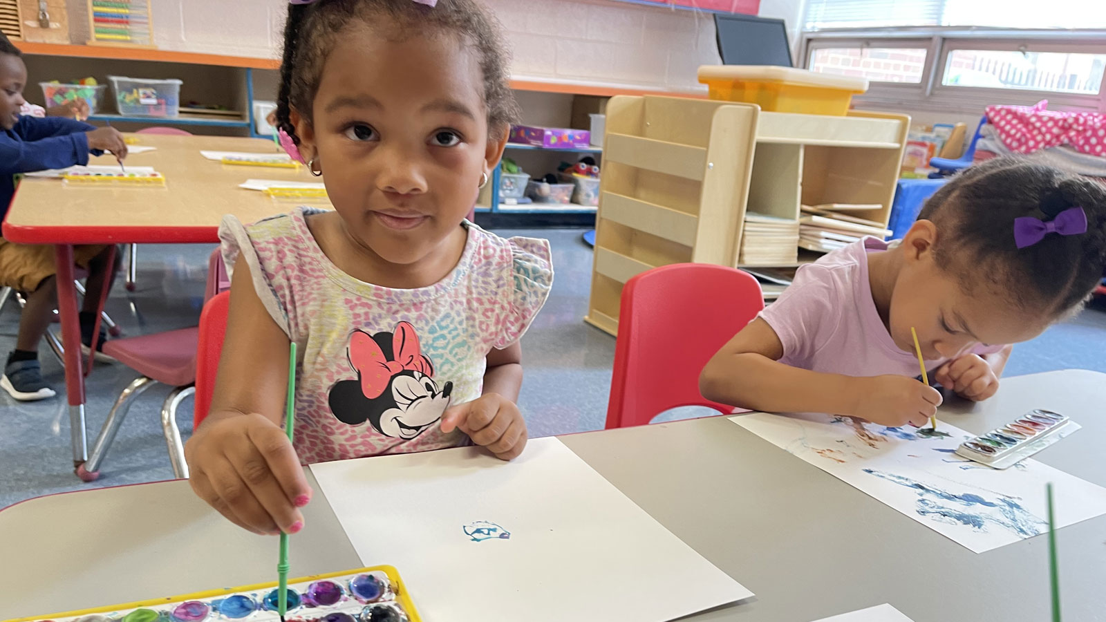 children painting a picture using paint