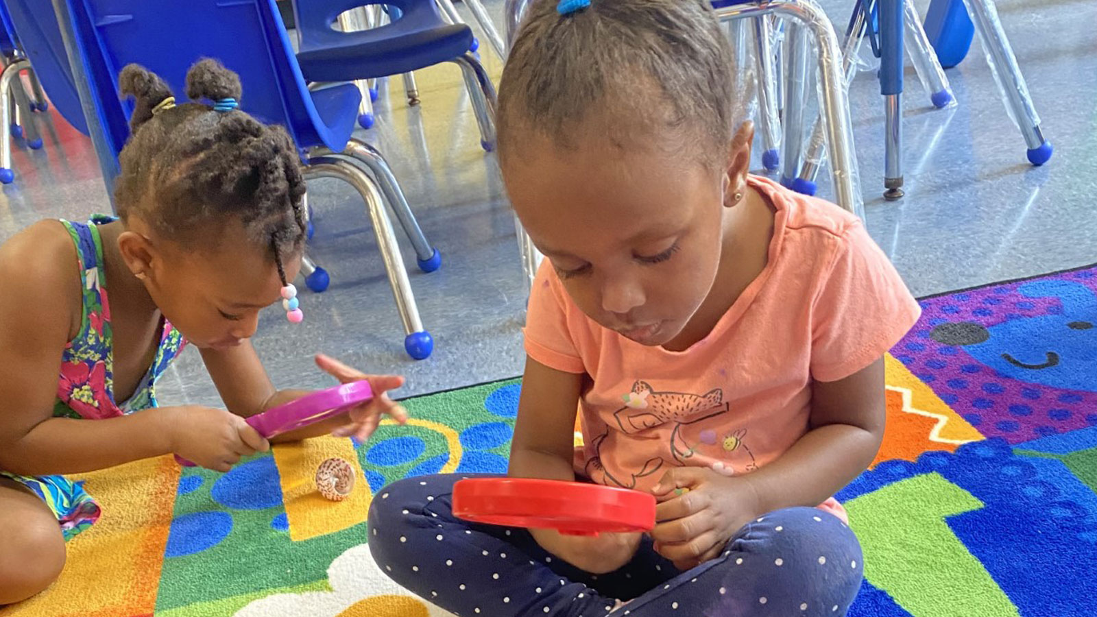 children using a magnifying glass to inspect objects