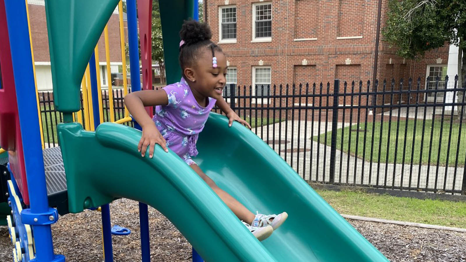 smiling child going down the slide