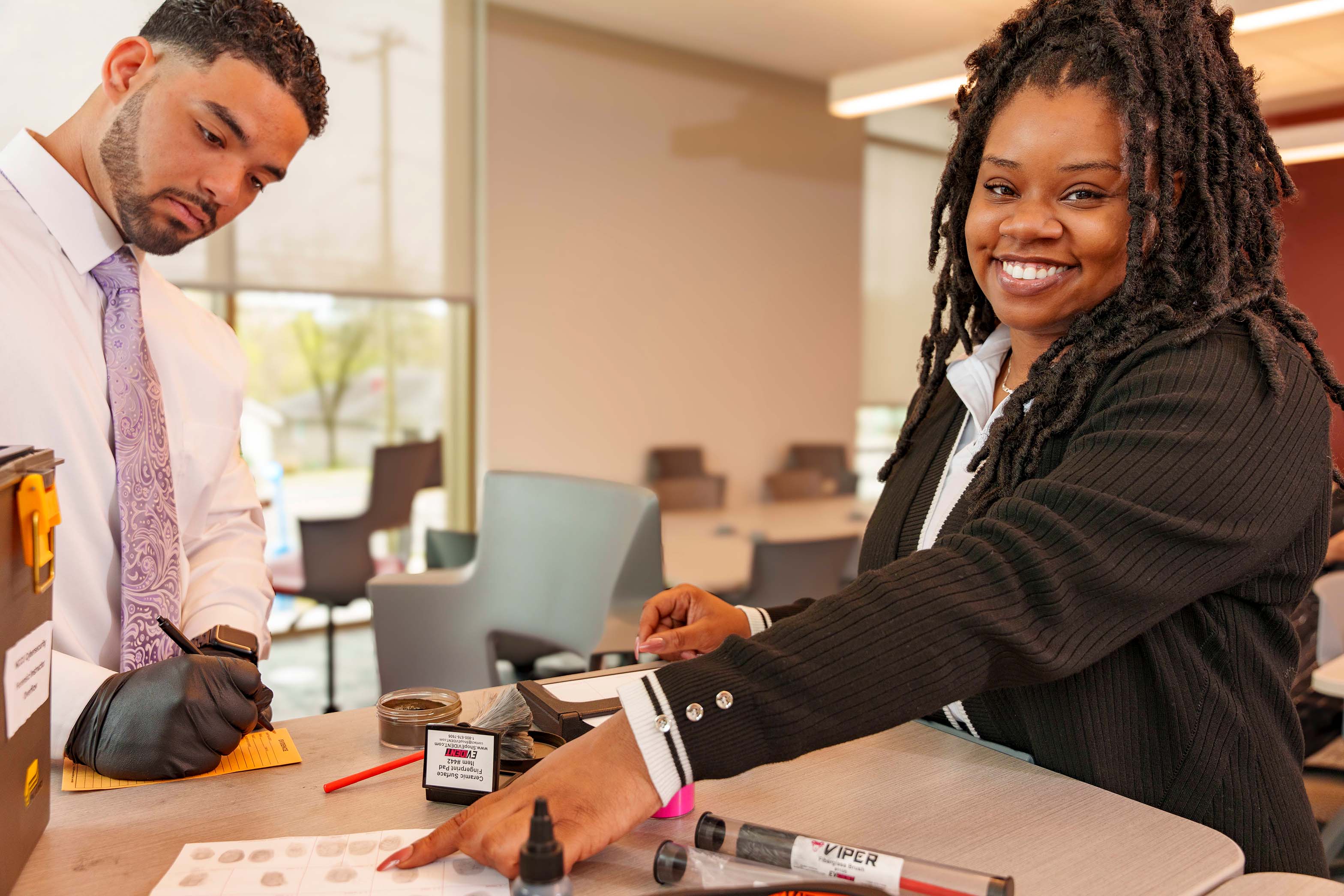 Two people taking finger prints