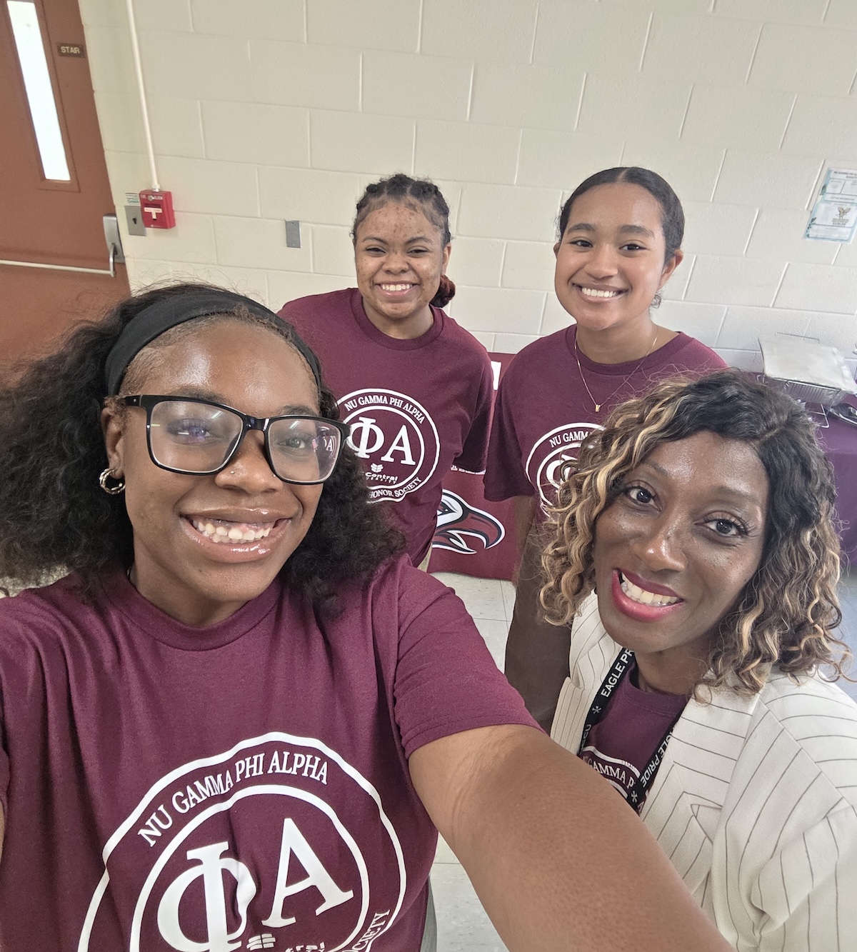 Four women looking at the camera and smiling