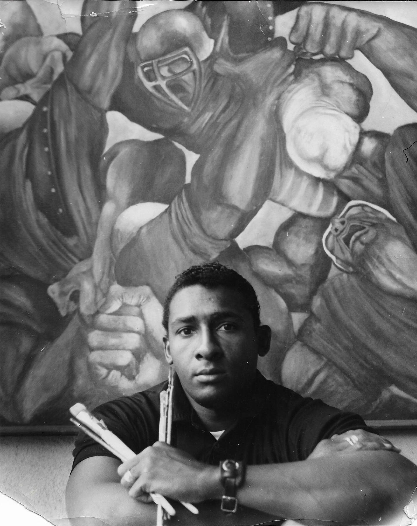 Ernie Barnes holding paint brushes