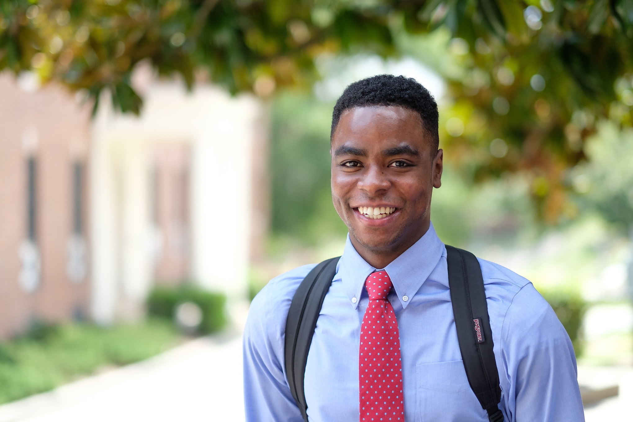 Student smiling at camera outside