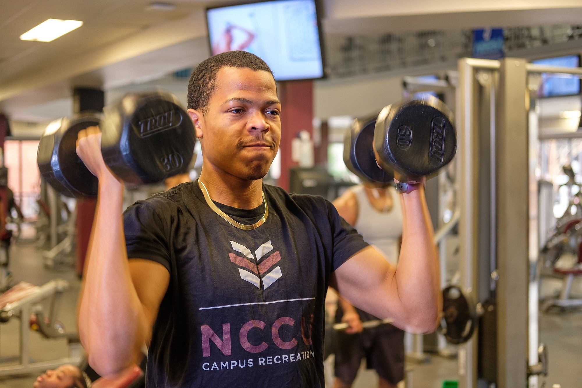 Student is lifting weight on fitness center