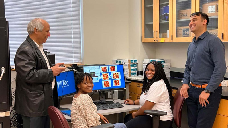 Dr Karoui and Dr Akram discussing with Physics graduate student, Ruth, and Chemistry student, Kristen, about fabricated piezoelectric being characterized with Raman Confocal spectroscopy.