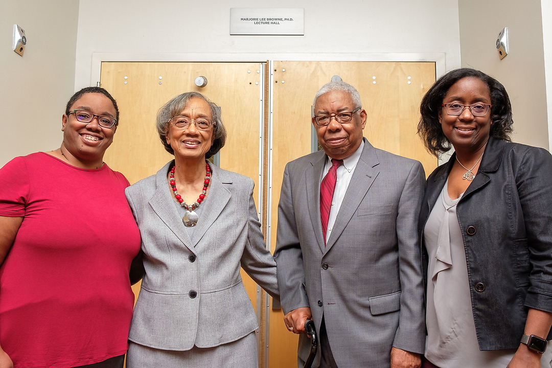 Alumni standing in front of a lecture hall