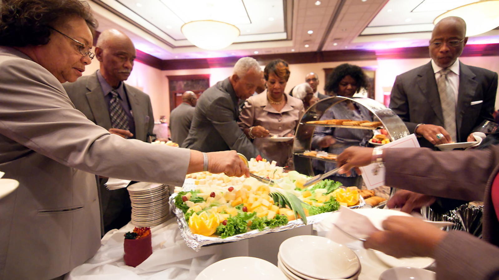 Alumni getting food from a buffet table