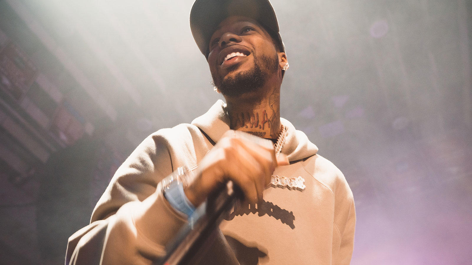 music artist holding a mic, smiling