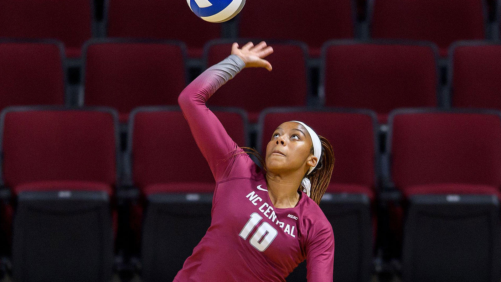 NCCU athlete mid-air, about to spike a volleyball