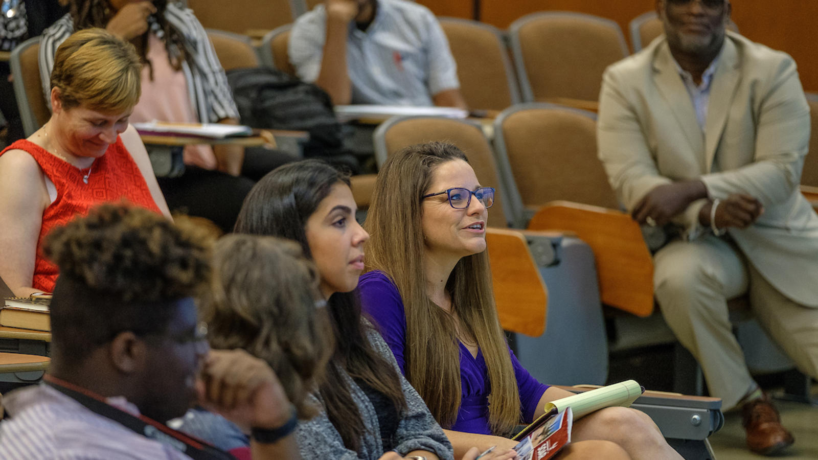 A diverse group listening to a lecture in a lecture hall