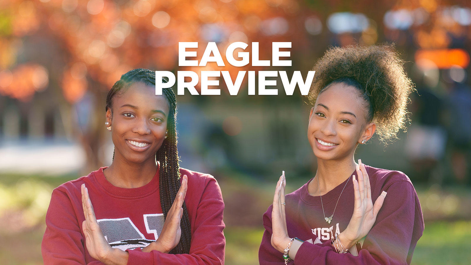 two nccu students holding up the eagle sign with the words "eagle preview" between them