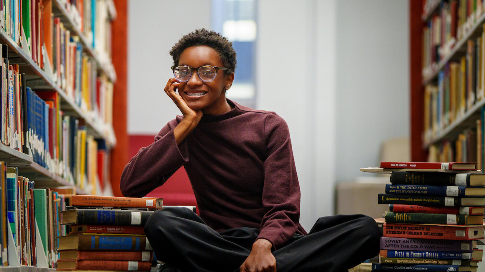 Haley Moore sitting in library against books