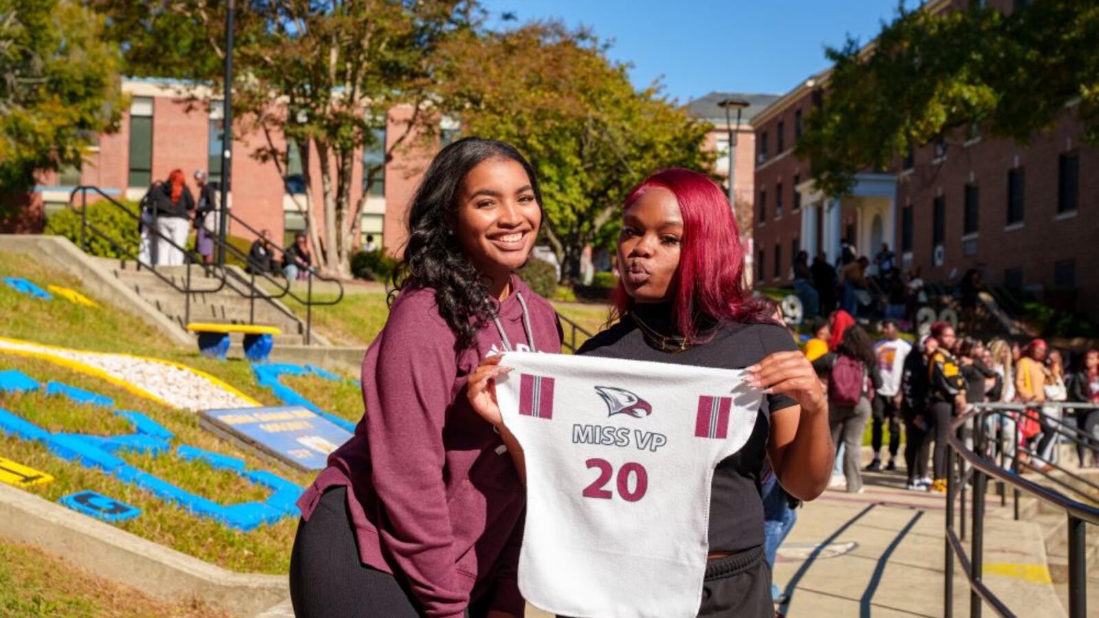 Image of two women holding an NCCU jersey