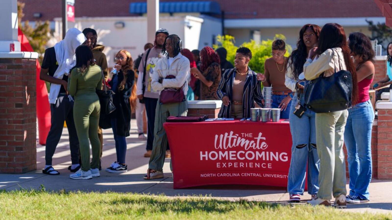 People standing around a Homecoming table