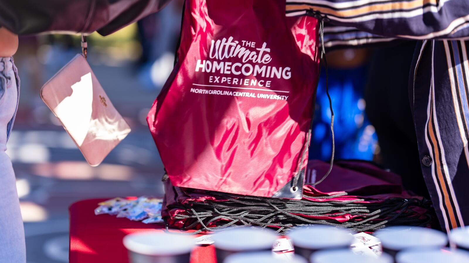 A stack of bags that say "The Ultimate Homecoming Experience"