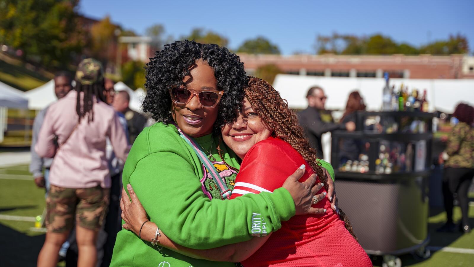 Two women hug at an outdoor event