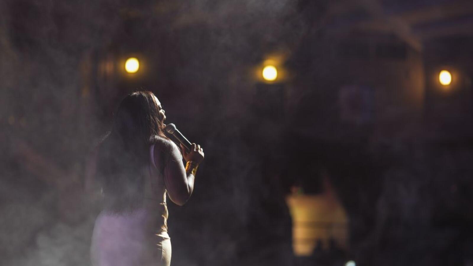 Image of a woman singing at a talent show