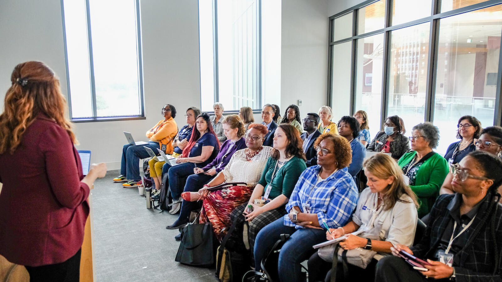People sitting in a large group and listening to a speaker