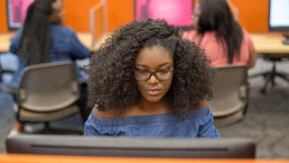 Student sitting at desk on a computer.