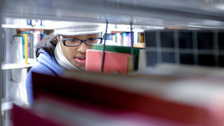 Student looking for books in library