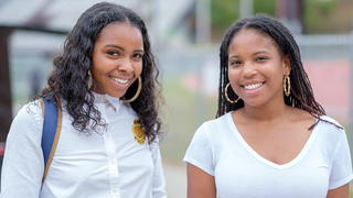 Two students smiling at the camera