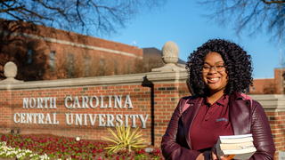 nccu student standing in front of sign