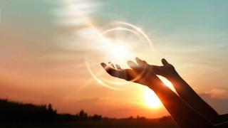 hands reaching into sunset