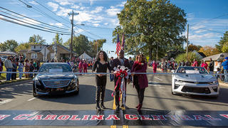 Homecoming parade with people standing.