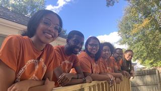 NCCU students standing infant of a fence