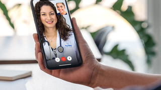 Stock image of a phone with FaceTime and a doctor.