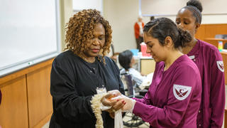 Student applying bandage to instructor