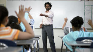 Male teacher in front of the classroom, teaching