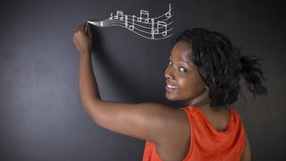 A girl drawing music symbols.
