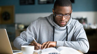 Student taking notes while studying