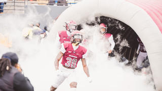 NCCU football players emerging from tunnel, covered in smoke