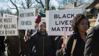 Students marching and holding signs regarding important social issues. 