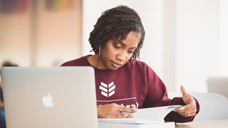 Student sitting at a desk reading a book