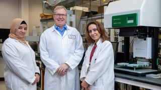 Three researchers smiling towards the camera